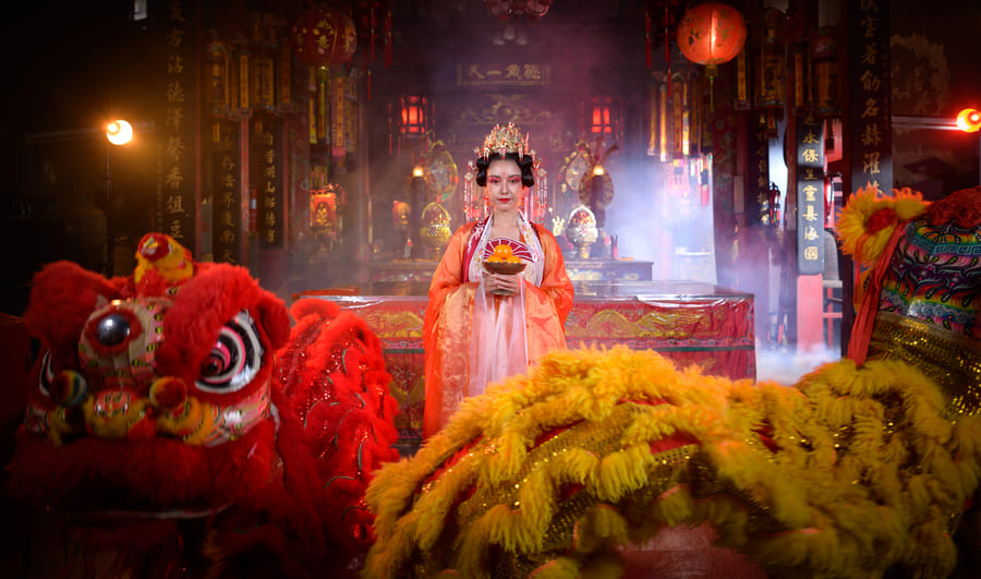 Mujer de rojo con leones chinos.